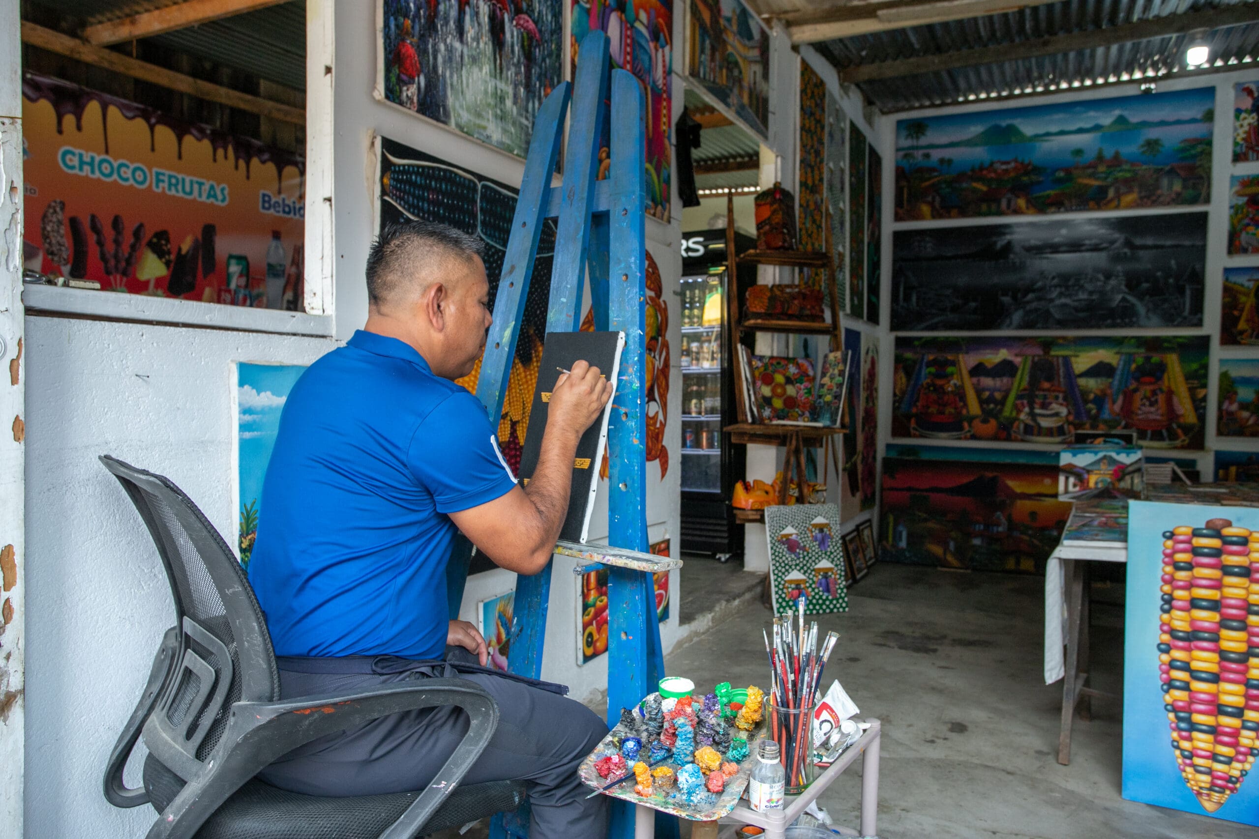 Artist paints on an easel in an art studio.