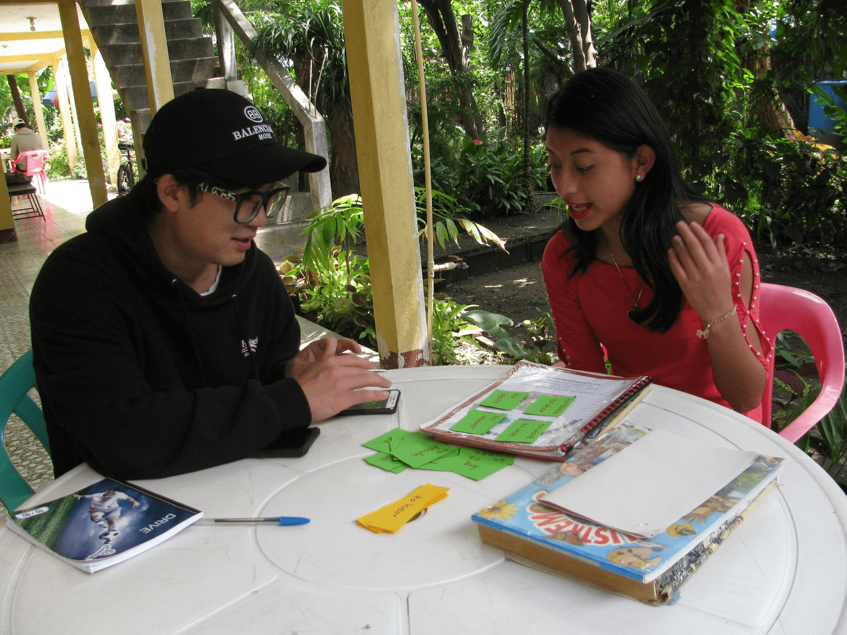 Two people sat around a table looking at study materials.