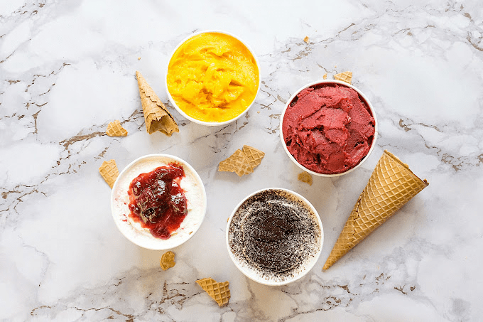 Four different flavours of ice cream in cups.