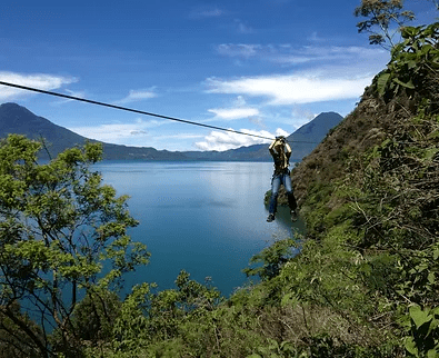 Zipline cable above the tree canopy with lake Atitlan behind.