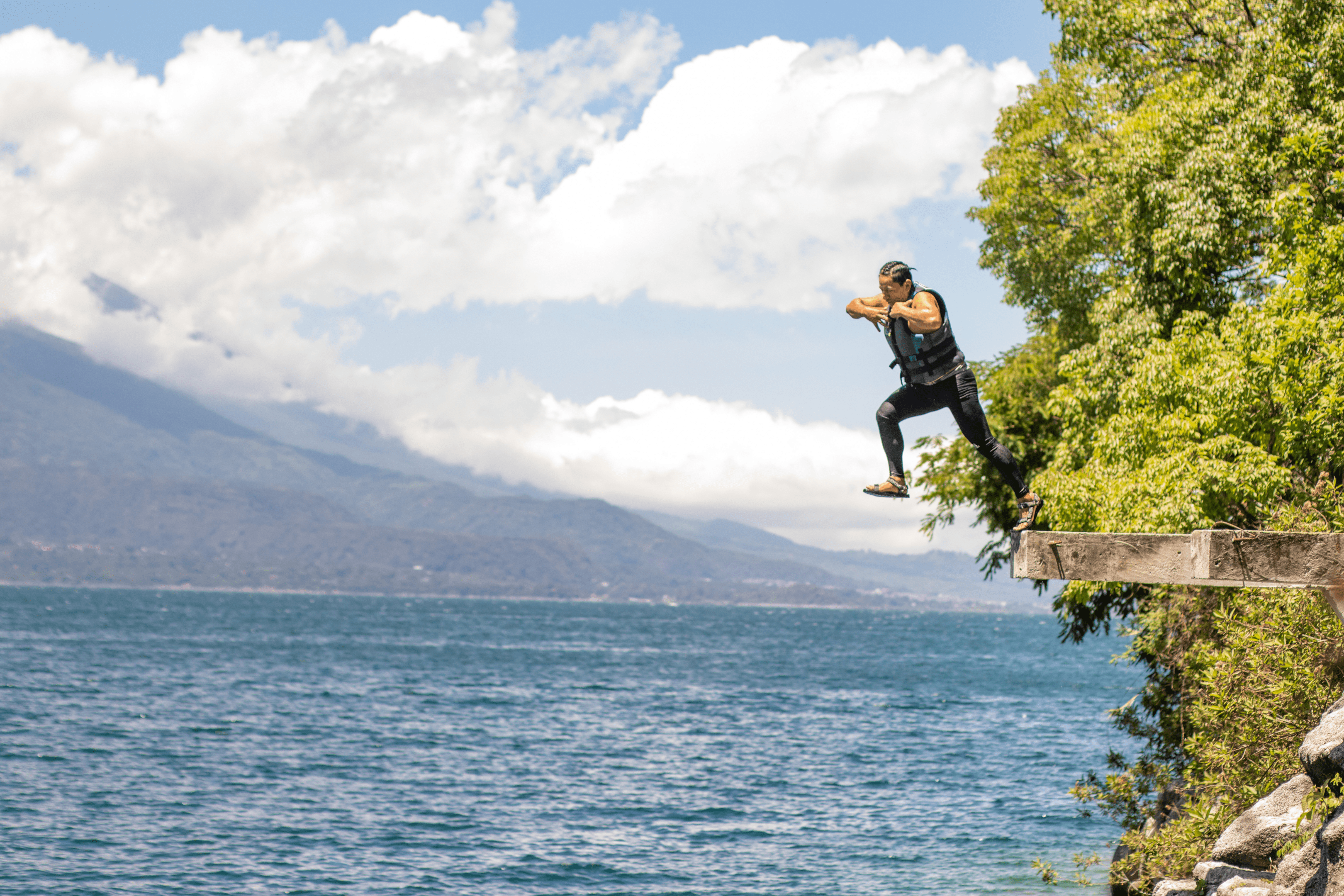 Man jumps from cliffside into huge lake below.