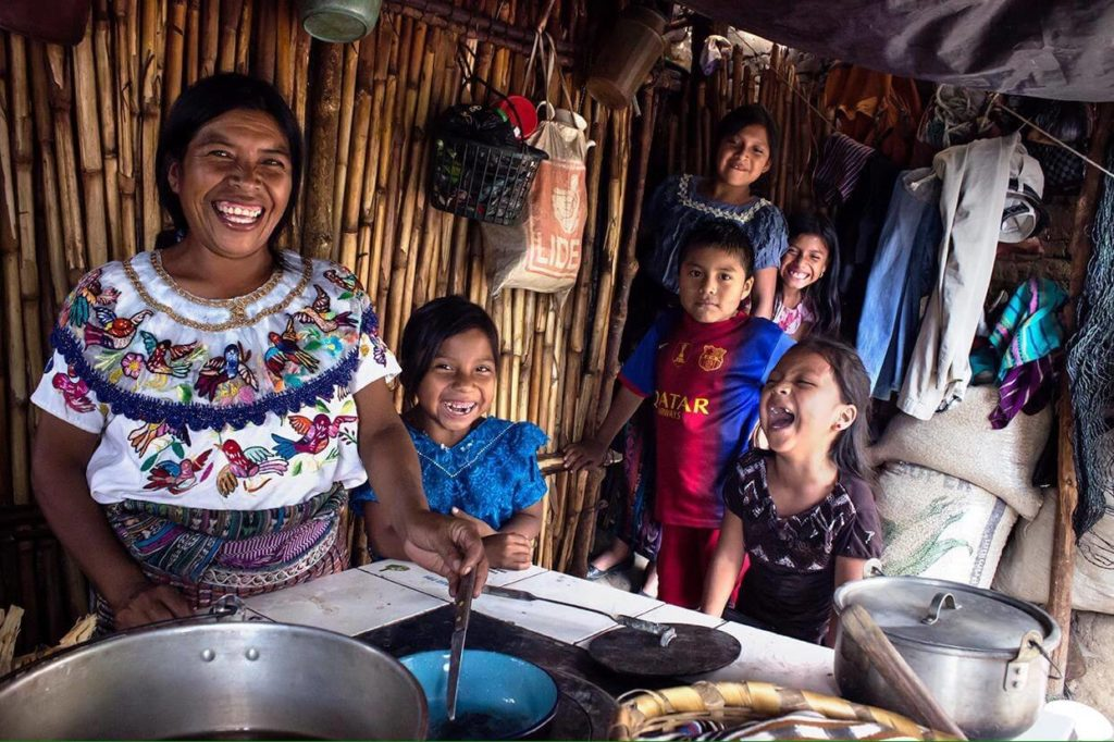 Indigenous people cooking traditional food in her home.