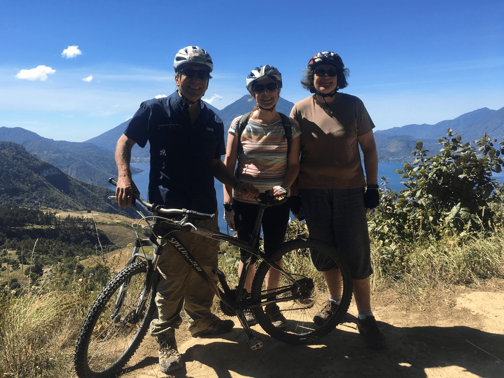 American tourists pose at the mountain summit with bikes